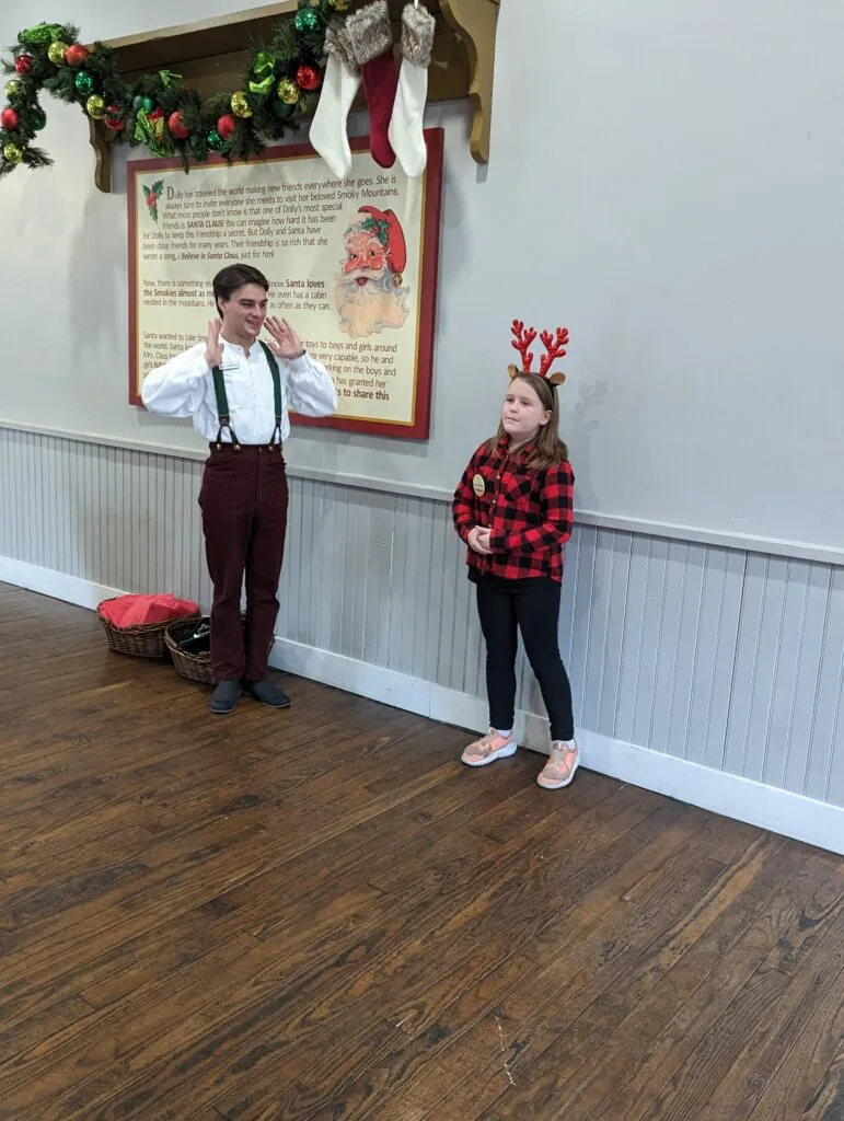 Are You Naughty or Nice? Discovering Santa's List at Dollywood 4 girl with reindeer antlers on at santas workshop in dollywood