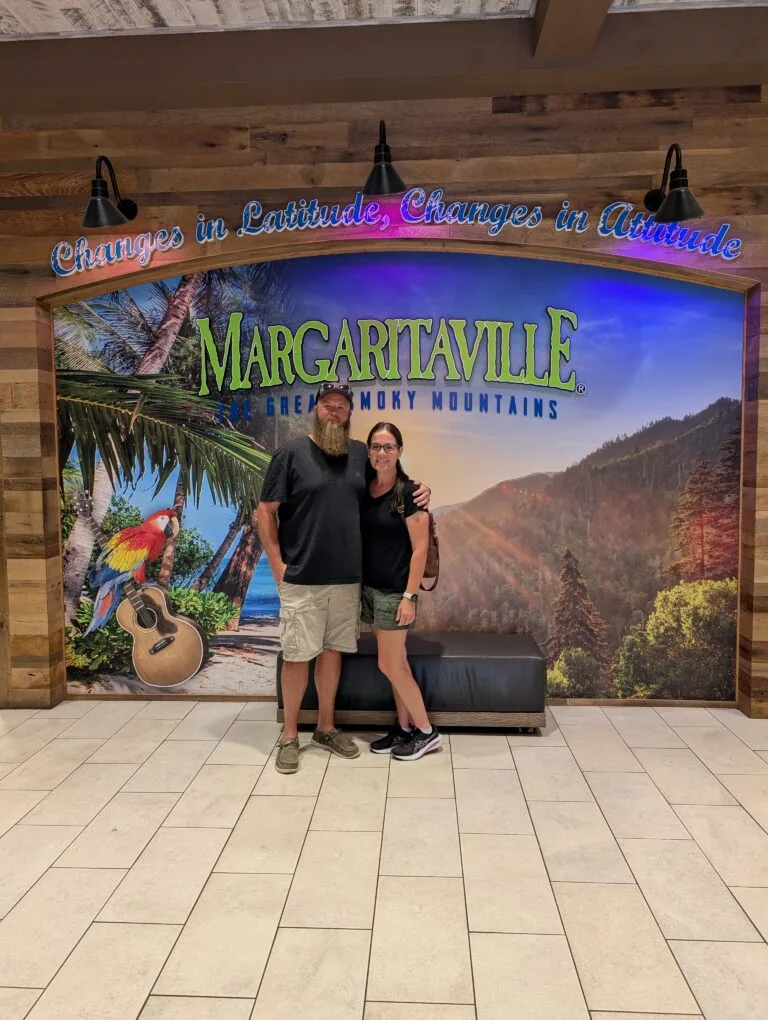 Couple standing in front of the backdrop in the lobby of Margaritaville Island Hotel in Pigeon Forge, TN