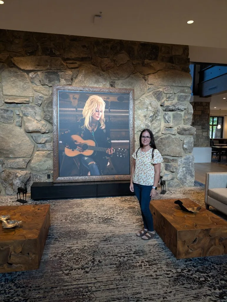 Lindsay Harvey in front of Dollyw Parton Portrait in Lobby at HeartSong Lodge and Resort
