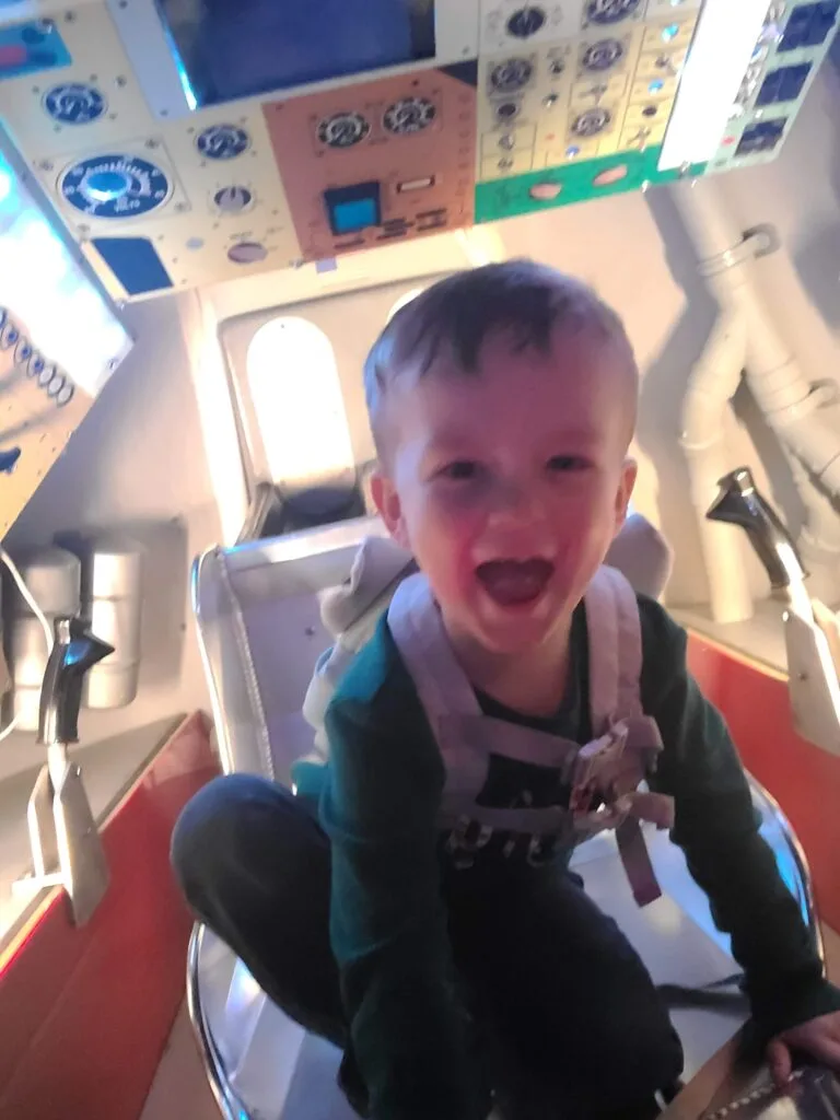 Child smiling big inside of exhibit at Wonderworks in Pigeon Forge, TN Photo Credit: Lindsay Harvey-Simply Touring