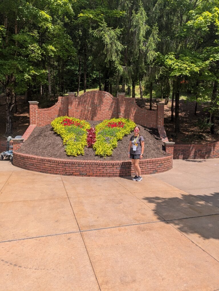 Lindsay Harvey with iconic butterfly topiary at Dollywood