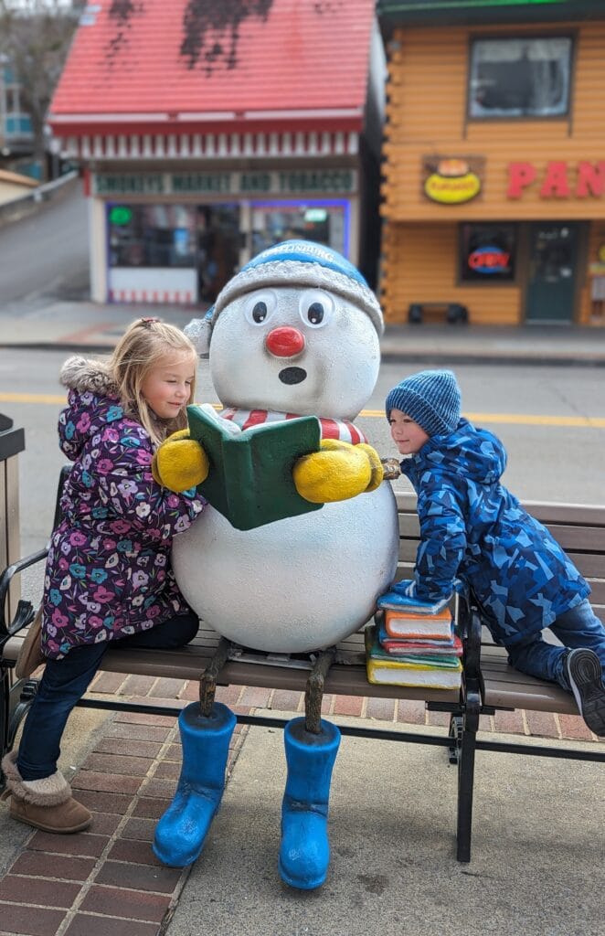 Children beside snoman on a bench in Gatlinburg during the Christmas season Photo Credit: Lindsay Harvey-Simply Touring