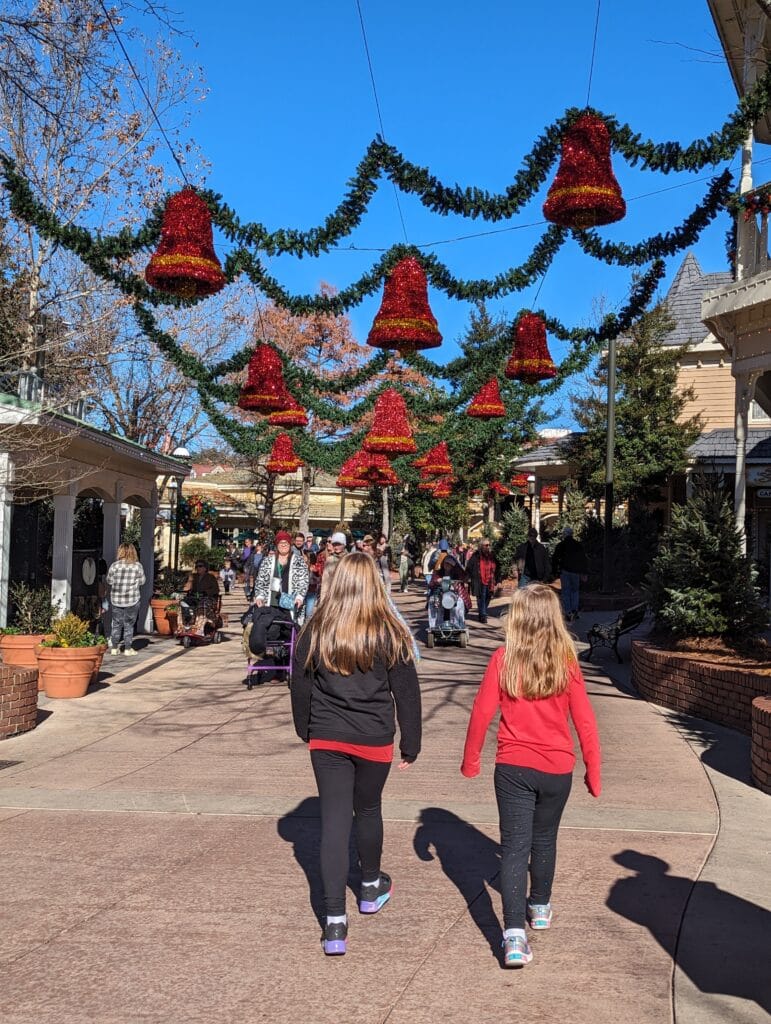 Children walking under garland and bell sky at Dollywood during Smoky Mountain Christmas Festival Photo Credit: Lindsay Harvey-Simply Touring